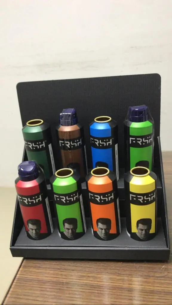 Black display tray holding eight aerosol bottles