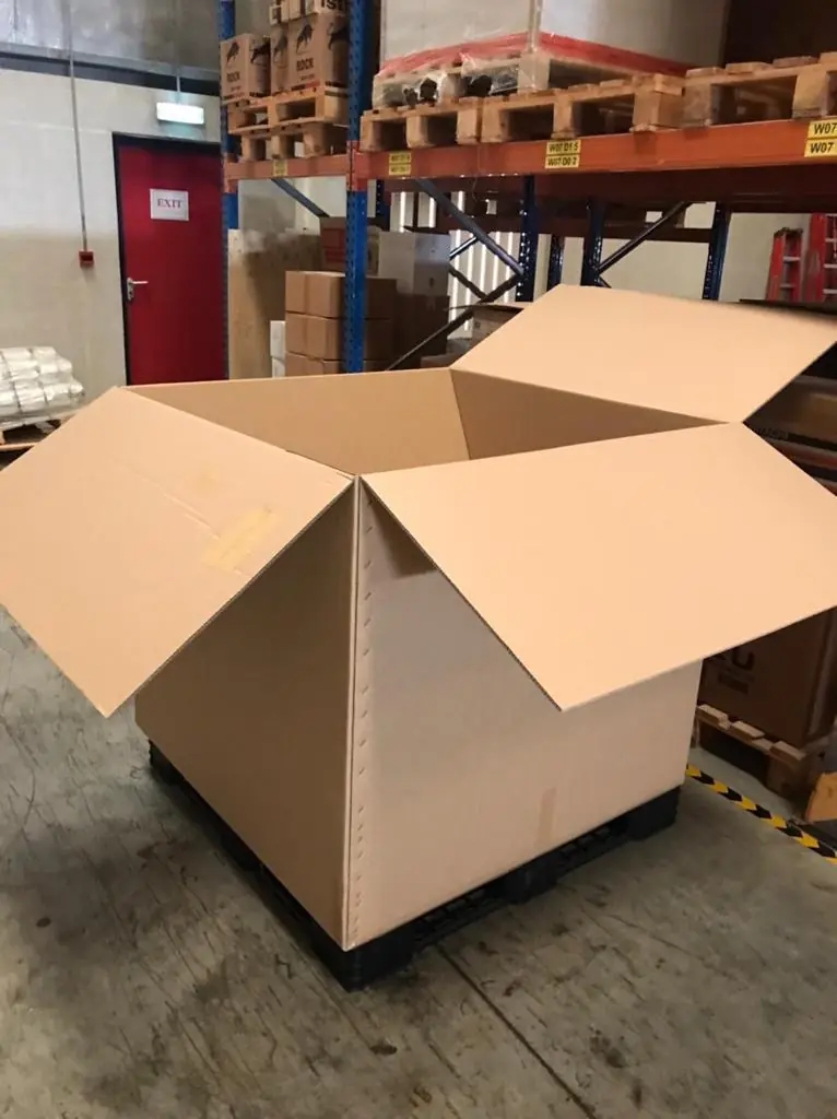 Large open brown cargo carton on a pallet in a warehouse